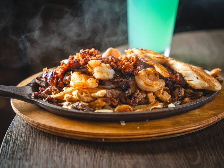 Fajitas mar y tierra sizzling with steak and shrimp